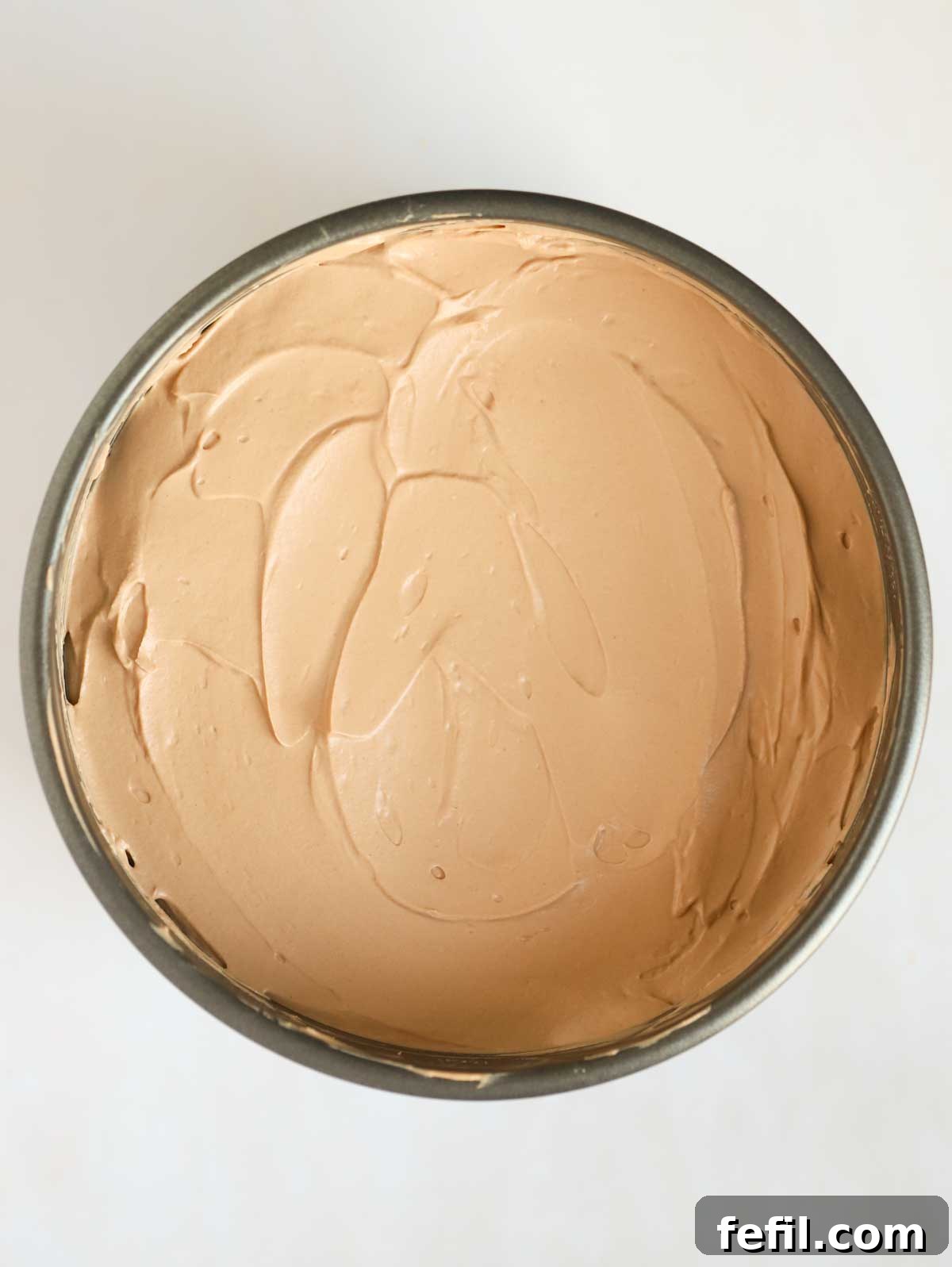 Whipped cream in a baking tin for for step 4 in the recipe for Nutella Cheesecake.