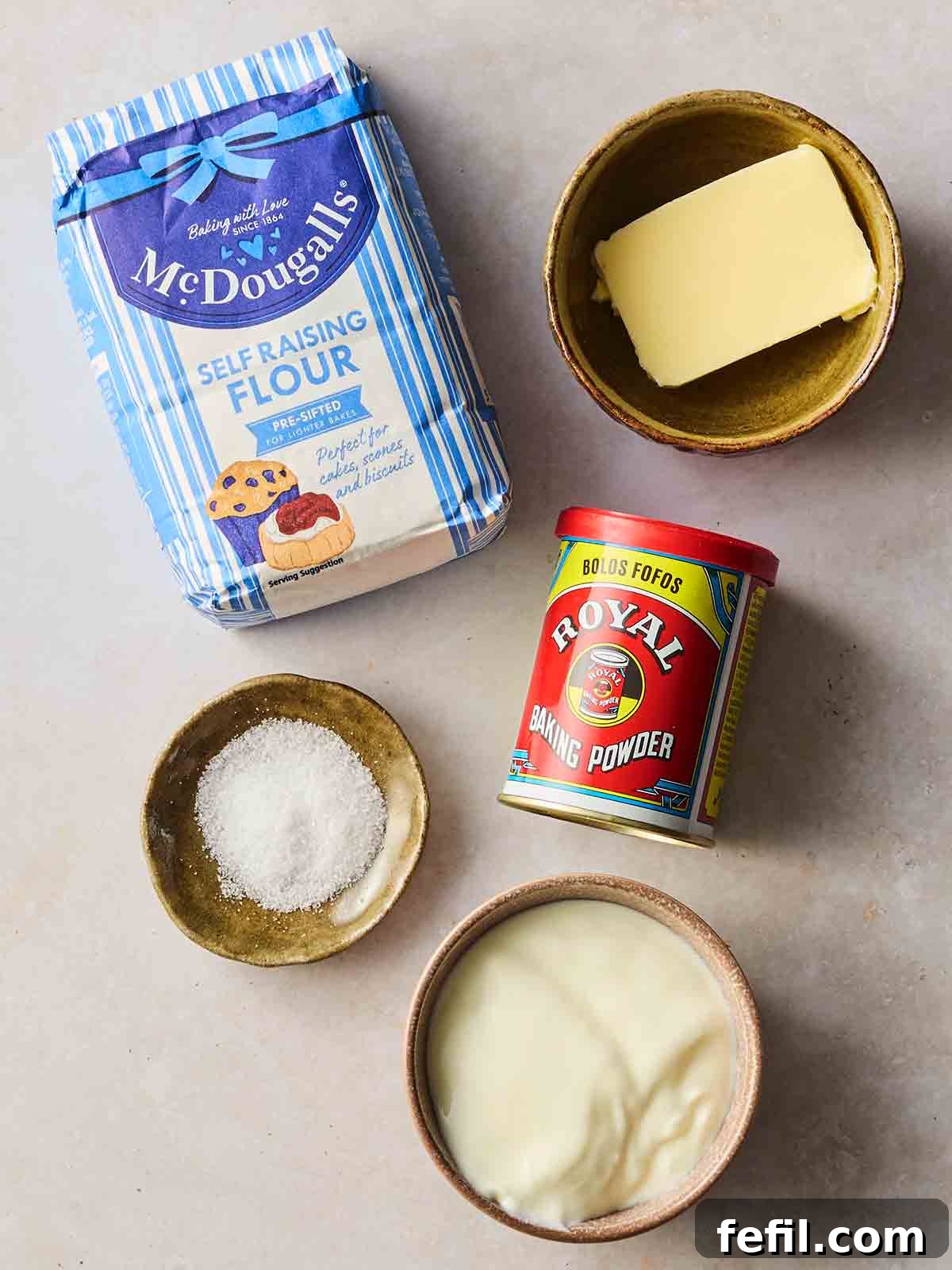 Ingredients for making homemade flatbreads laid out on a white surface, including yogurt, flour, baking powder, and salt.