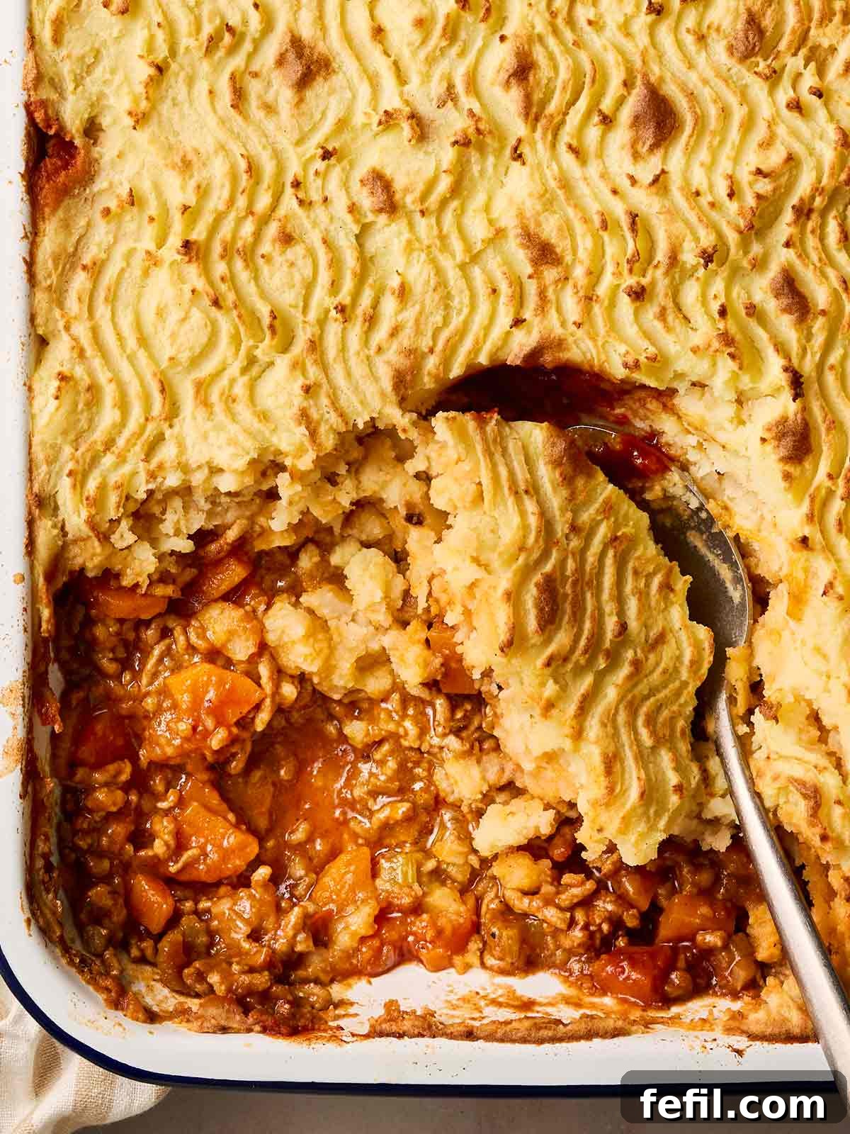 Homestyle Shepherd's Pie 3 A close up of a classic shepherd's pie being served up with a spoon.