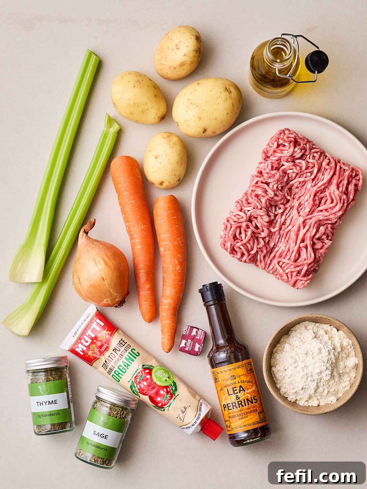 Homestyle Shepherd's Pie 4 Raw ingredients laid out on a counter top for shepherd's pie, including mince, vegetables, tomato puree, herbs, Worcestershire sauce and flour.