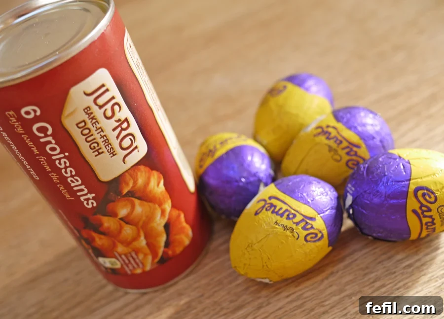 Ingredients for Cadbury Caramel Egg Stuffed Croissants laid out: croissant dough, caramel eggs, and a beaten egg.