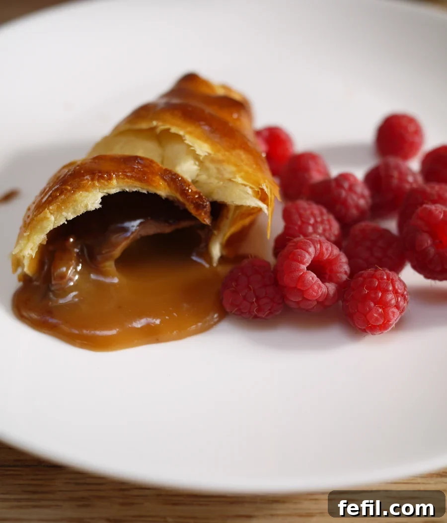 A Cadbury Caramel Egg Croissant sliced open, showcasing the molten caramel filling.