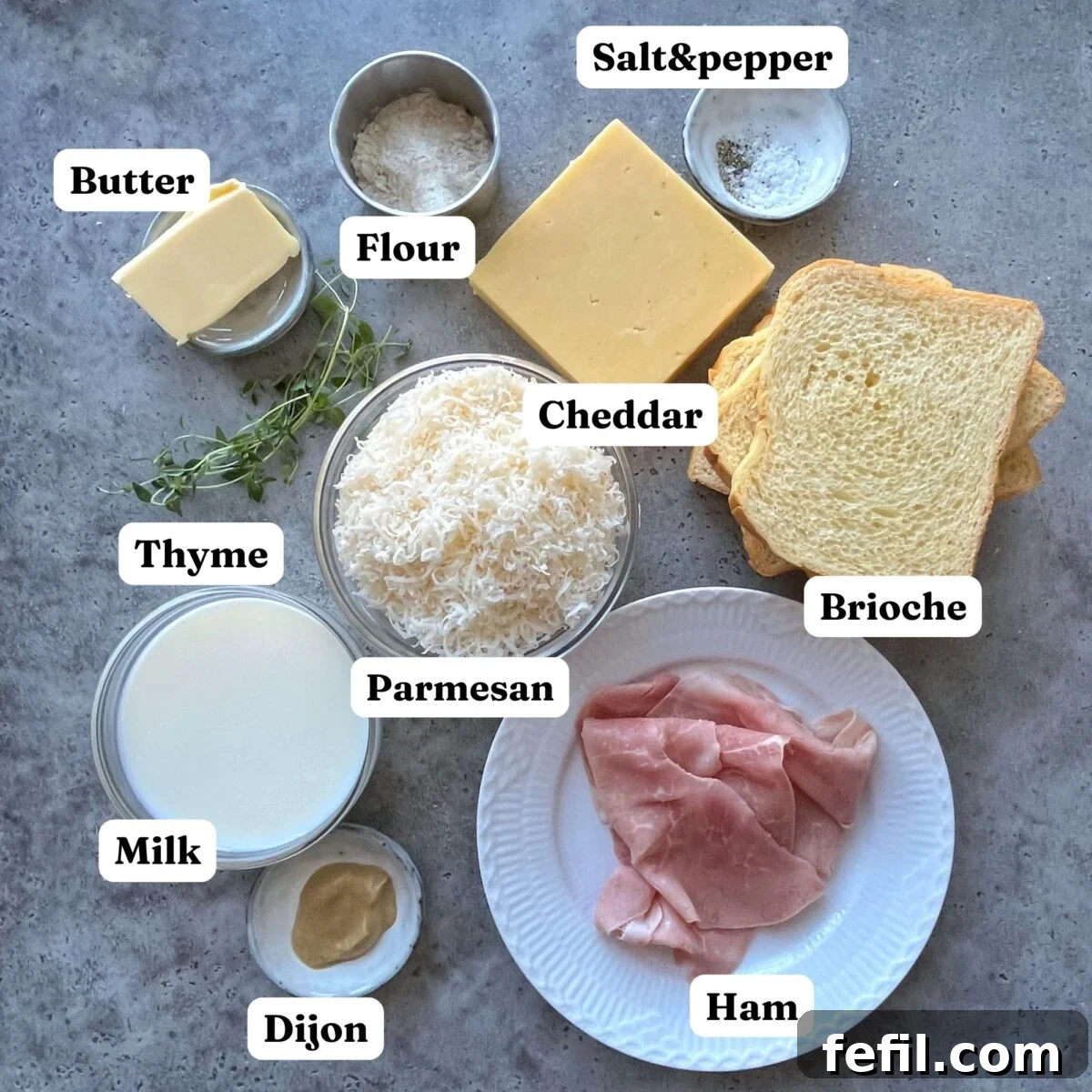 Golden Baked Ham and Cheese Sandwich 5 A curated display of essential ingredients for crafting a Croque Monsieur: perfectly sliced ham, soft brioche toast, blocks of cheddar and Parmesan cheese, fresh butter, all-purpose flour, rich milk, piquant Dijon mustard, fragrant fresh thyme, and seasonings of salt and pepper. All arranged artfully for a gourmet culinary experience.