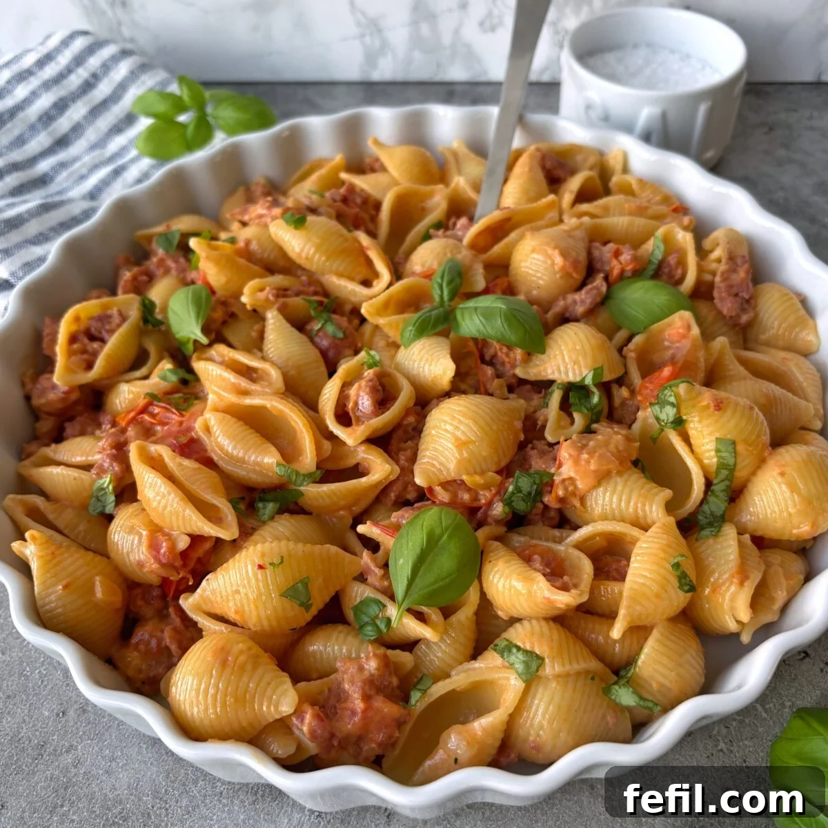 Spicy Italian Sausage Pasta Recipe 3 A side view of Spicy Italian Sausage Pasta topped with a spoon.
