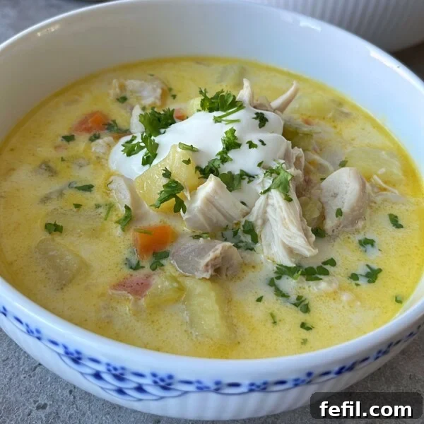 A bowl of creamy Chicken Potato Soup with tender chicken, potatoes, and carrots.