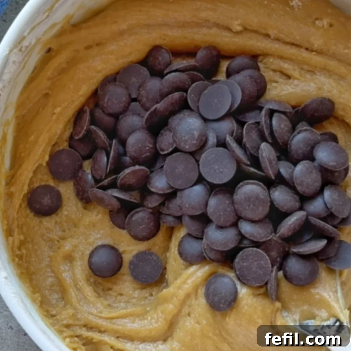 Gooey Chocolate Chip Skillet Cookie Recipe 7 Cookie dough topped with chocolate chips, ready to be folded in.