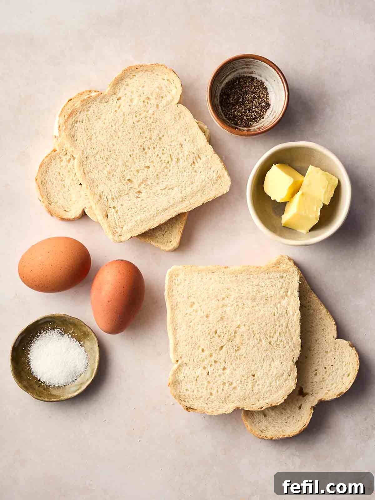 How to Make Classic Eggy Bread (British-Style French Toast) 4 The ingredients for making Eggy Bread laid out on a white counter top.