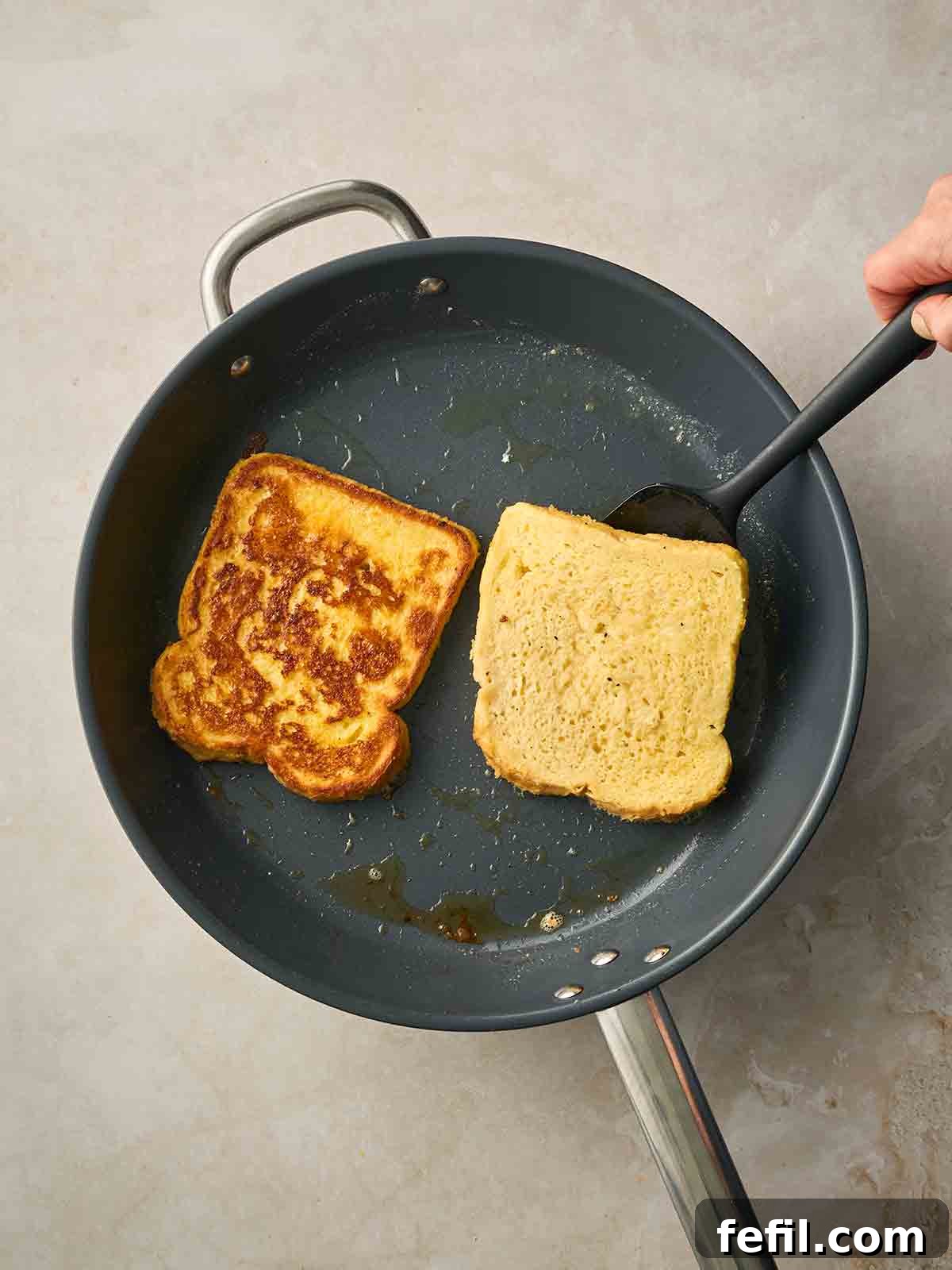 How to Make Classic Eggy Bread (British-Style French Toast) 8 Two slices of white bread frying in a pan to make Eggy Bread.