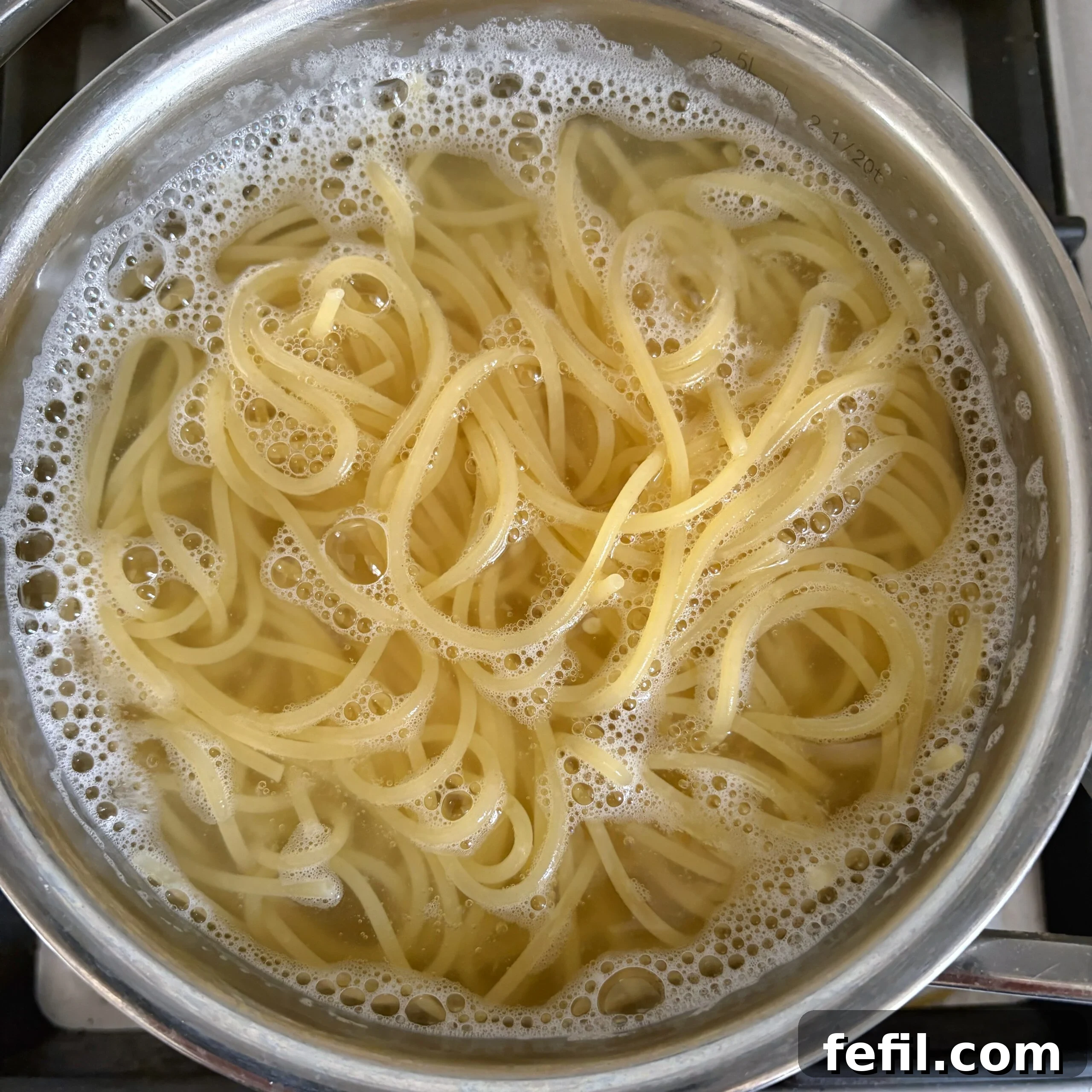 Spooky Halloween Spaghetti with Creepy Meatball Eyes 5 Spaghetti cooking in boiling water.