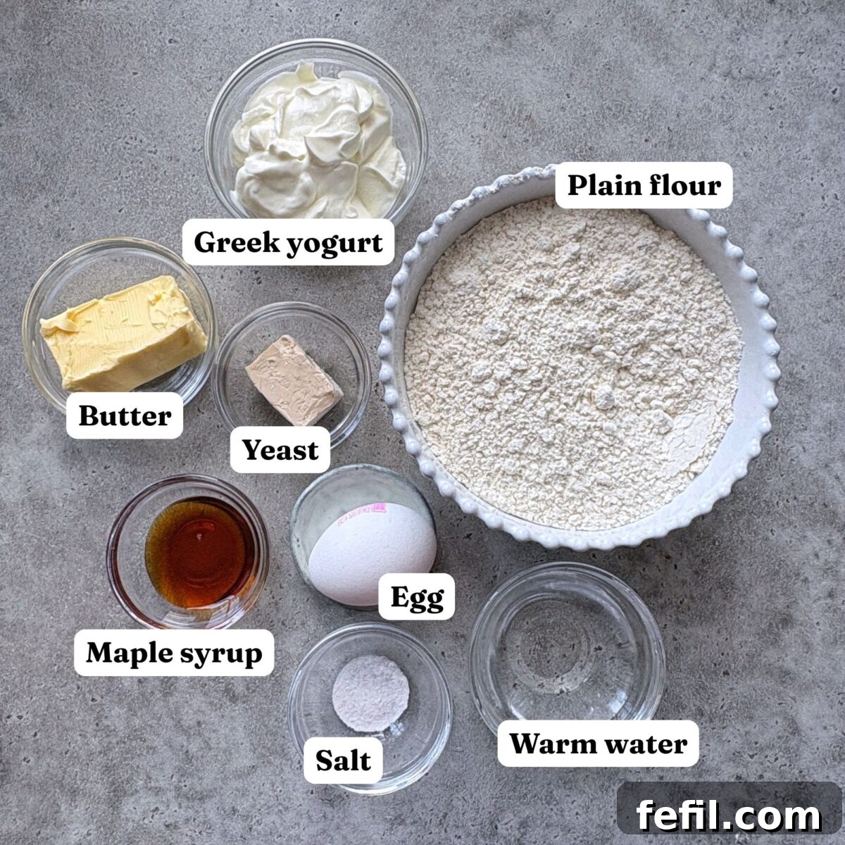 Mini Cinnamon Roll Bites with Cream Cheese Glaze 4 Ingredients for mini cinnamon rolls including plain flour, butter, maple syrup, yeast, baking powder, milk and one egg.
