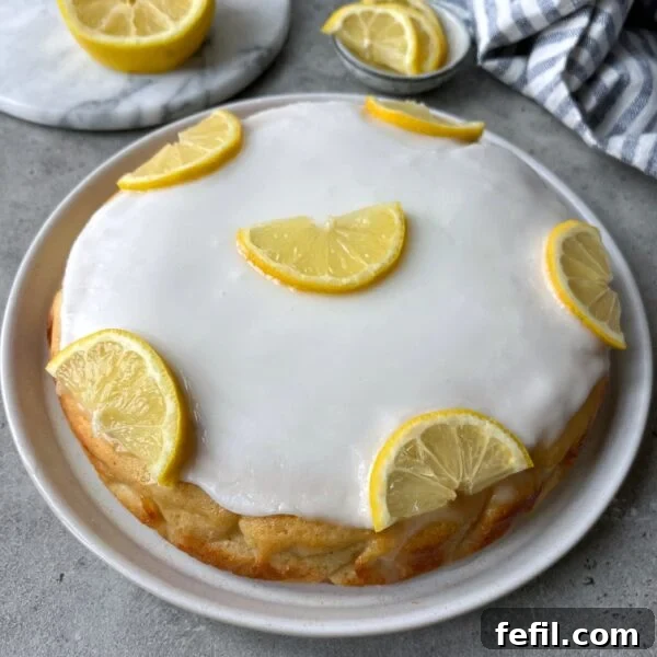 Classic Cinnamon Apple Cake with Warm Spice Glaze 12 Round lemon cake with white icing, topped with six halved lemon slices.