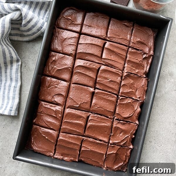 Classic Cinnamon Apple Cake with Warm Spice Glaze 13 A rectangular baking pan filled with a chocolate cake topped with chocolate frosting and cut into even squares.