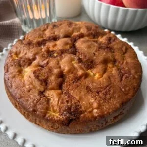 Classic Cinnamon Apple Cake with Warm Spice Glaze 16 A golden-baked Cinnamon Apple Cake on a white platter.
