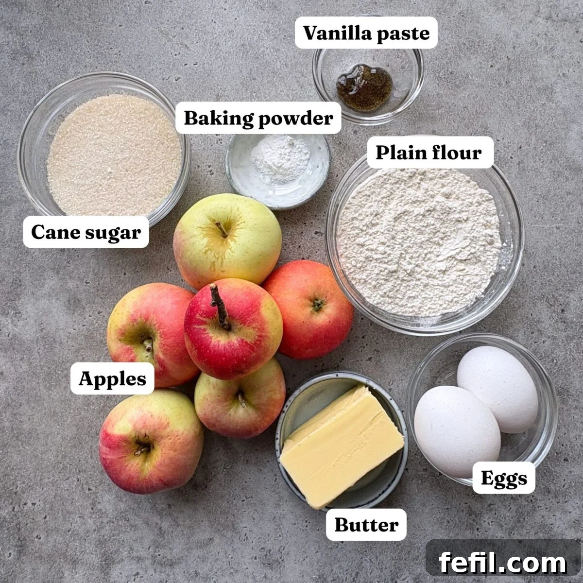 Classic Cinnamon Apple Cake with Warm Spice Glaze 5 Ingredients for Cinnamon Apple Cake, featuring bowls or cane sugar, vanilla paste, eggs, butter, plain flour, baking powder, and apples.
