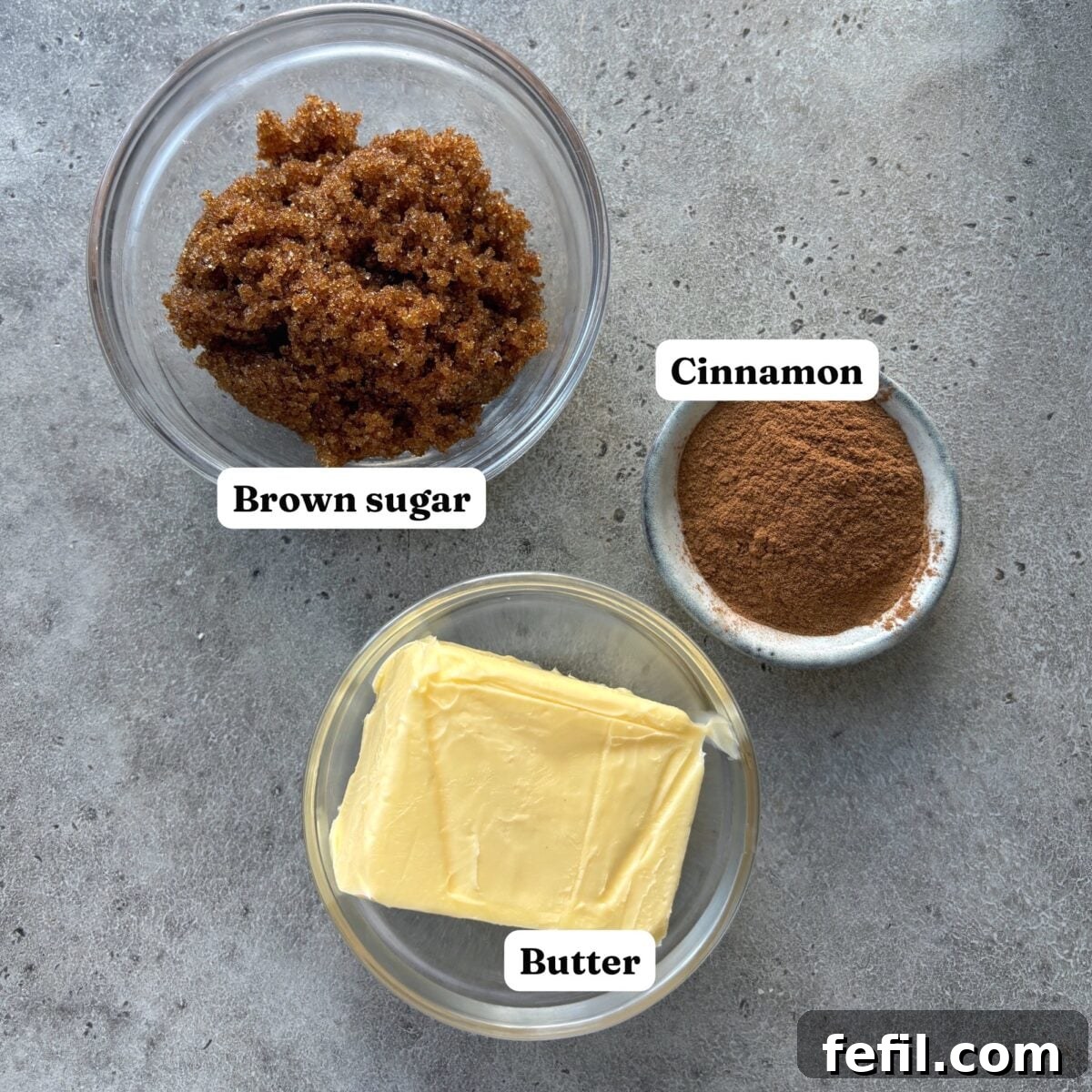 Classic Cinnamon Apple Cake with Warm Spice Glaze 6 Three labeled bowls with brown sugar, cinnamon, and butter are arranged on a gray surface.