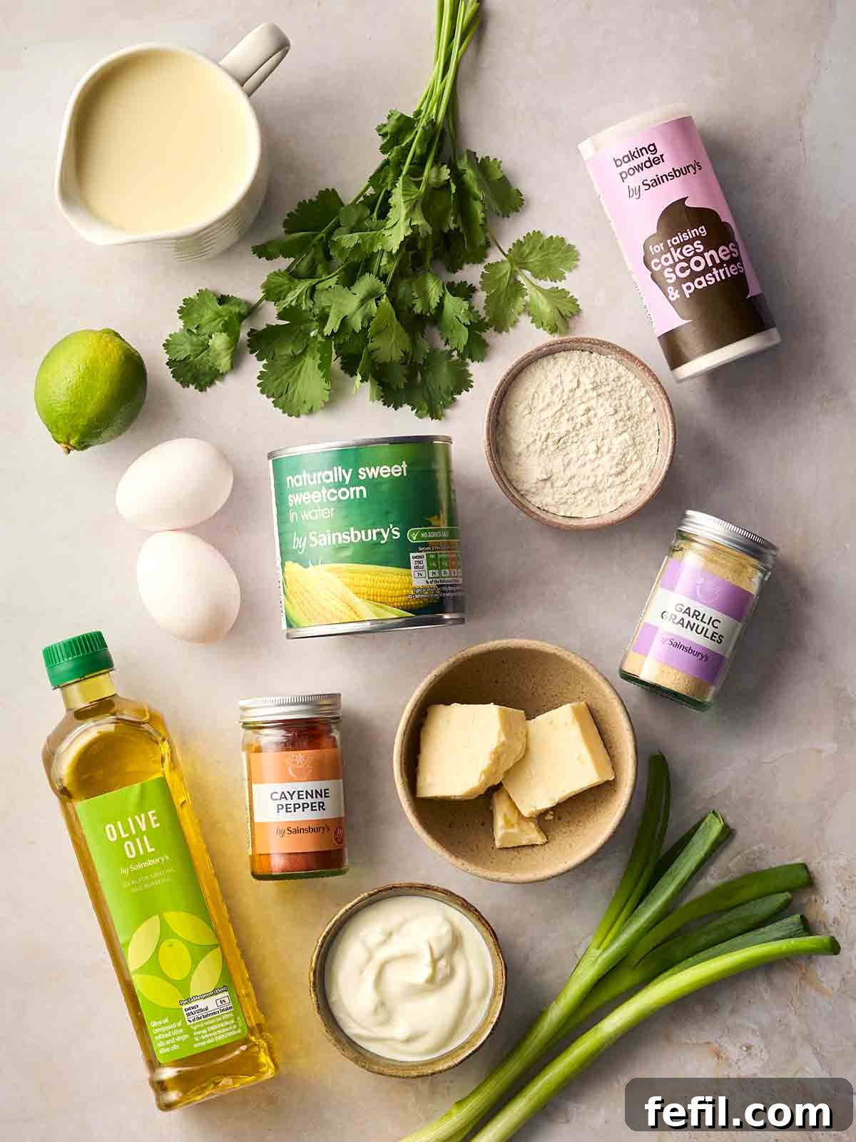 Crispy Sweetcorn Fritters Recipe 4 The ingredients for making sweetcorn fritters laid out on a white surface.