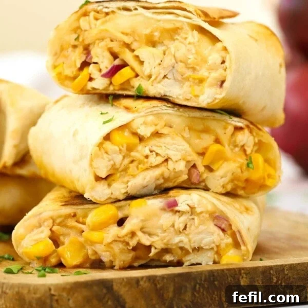 A stack of sliced cooked chicken wraps with cheese and sweetcorn, ready to serve.