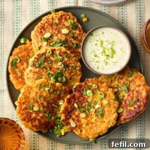 Crispy Sweetcorn Fritters Recipe 9 A plate of Sweetcorn Fritters with a yoghurt dip, on a tablecloth with green stripes, ready to serve.