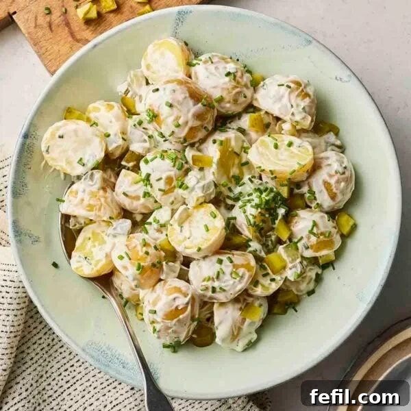 Perfect Crispy Garlic Bread with Herbed Butter 5 A classic potato salad in a bowl, with sprinkled chives over the top, and a spoon in.