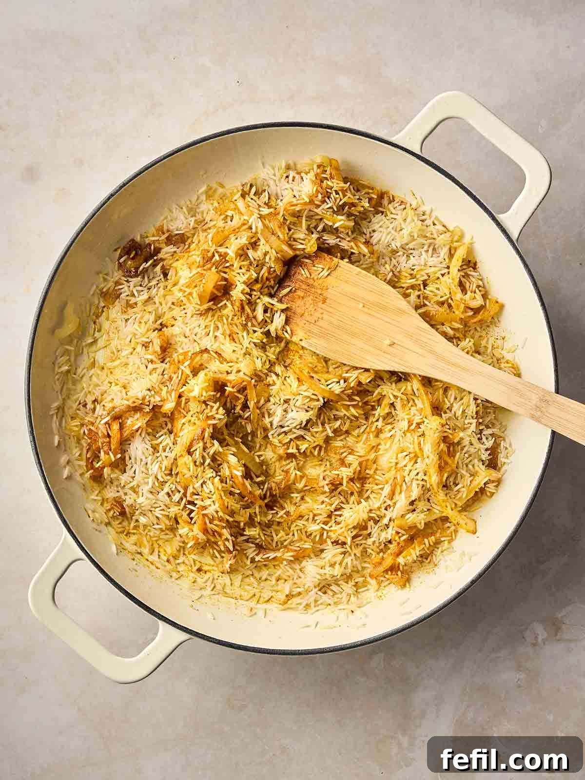 Classic Kedgeree: Smoked Fish, Rice & Curried Eggs 8 A pan of rice cooking with spices and onion.