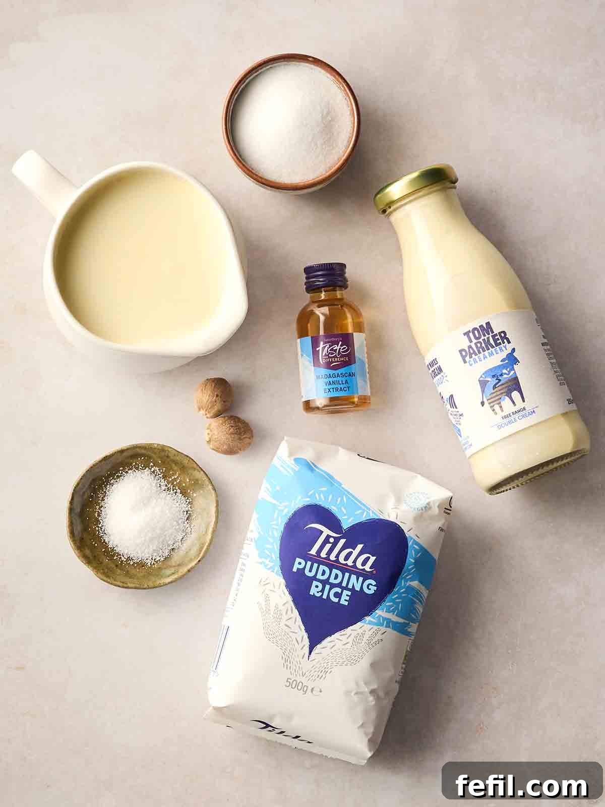 Creamy Slow Cooker Rice Pudding Recipe 4 The ingredients for making slow cooker rice pudding laid out on a white counter top.