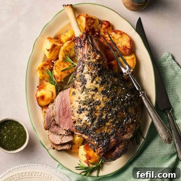 How to Make Crispy Pork Belly with Perfect Crackling Skin 6 A roasted leg of lamb on a platter with roast potatoes to the side.